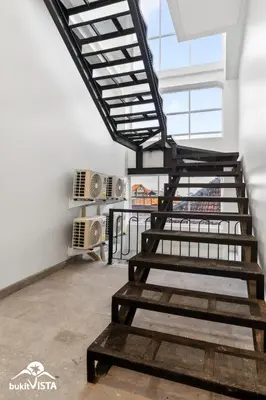 a metal staircase in a room with a window at Hummingbird Villa by Bukit Vista in Kerobokan