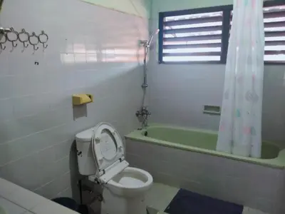 a bathroom with a toilet and a bath tub at Widi House in Nusa Dua