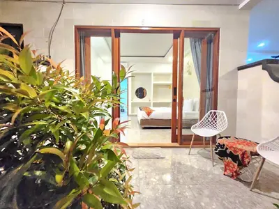 a room with a bedroom with a bed and a mirror at Ratu Guest House in Mantaak