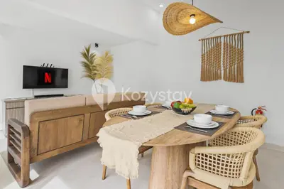a dining room with a wooden table and chairs at Surbiton Villa by Kozystay - Seminyak in Seminyak
