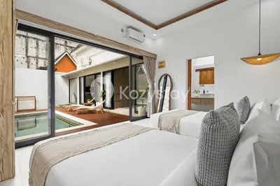 a bedroom with two beds and a swimming pool at Surbiton Villa by Kozystay - Seminyak in Seminyak