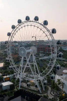 a ferris wheel in front of a city at The Wheel Bali in Canggu