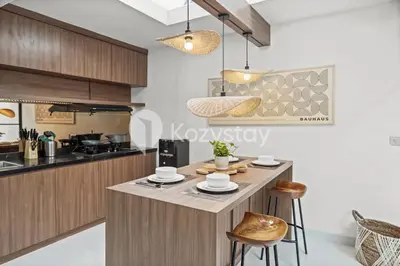 a kitchen with a island with chairs and a counter top at Biyan Villa by Kozystay - Seminyak in Seminyak