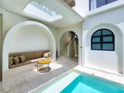 a house with a swimming pool and a living room at Villa Emilia Canggu by Nagisa Bali in Canggu