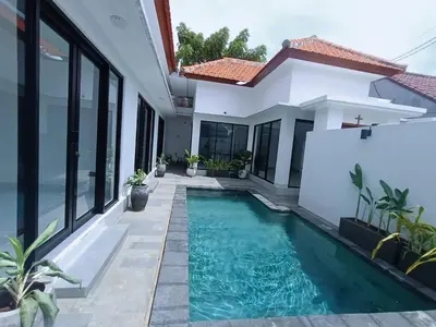 a swimming pool in front of a house at Villa umalas in Seminyak