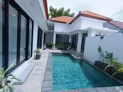 a swimming pool in front of a house at Villa umalas in Seminyak