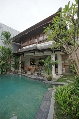 a house with a swimming pool in front of it at Juan Villa Legian in Seminyak
