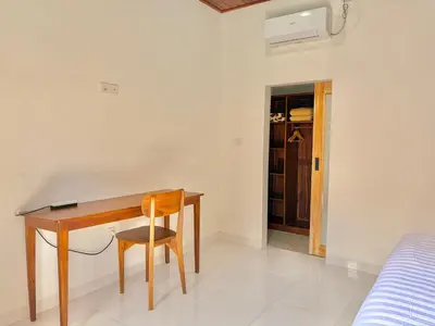 a desk in a bedroom with a bed and a chair at Tanhana Seminyak in Kerobokan