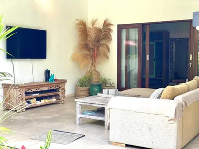 a living room with a couch and a tv at Superb Location! Modern 2BR Seminyak Oasis with Pool & Garden in Seminyak