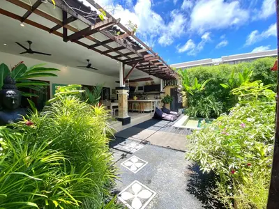 an outdoor patio with a pergola and plants at Superb Location! Modern 2BR Seminyak Oasis with Pool & Garden in Seminyak