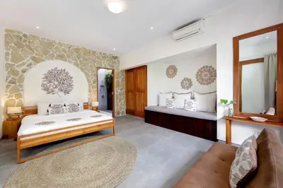 a bedroom with a king sized bed and a couch at 6BR Seminyak Oasis with 2 Private Pools in Seminyak