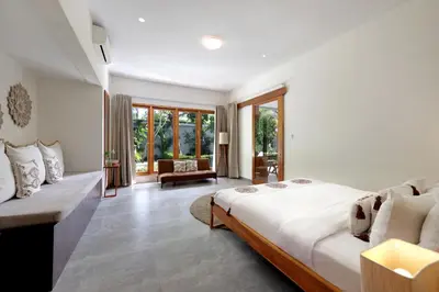 a bedroom with a large bed and a couch at 6BR Seminyak Oasis with 2 Private Pools in Seminyak
