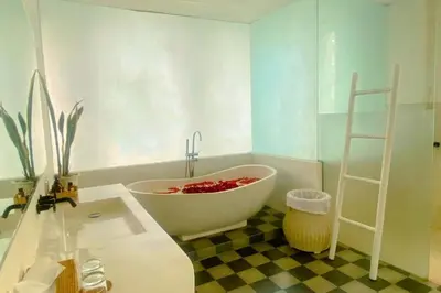 a bathroom with a large white bath tub next to a sink at Yelena Spacious 3 BR Private Pool Villa in Canggu