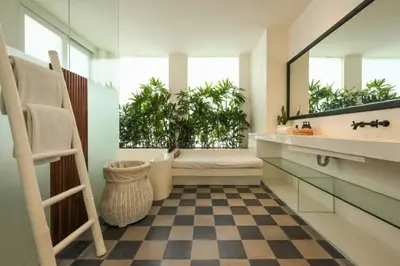 a bathroom with a checkered floor and a mirror at Yahira Stunning Garden 5 BR Private Pool Villa in Canggu