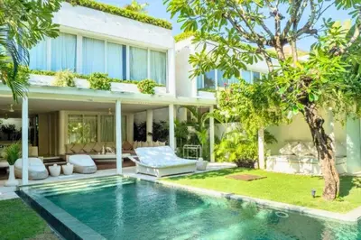 a villa with a swimming pool in front of a house at Yahira Stunning Garden 5 BR Private Pool Villa in Canggu