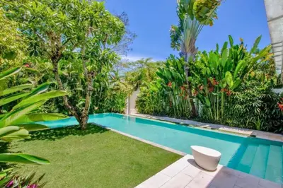 a swimming pool in a garden with trees and plants at Yahira Stunning Garden 5 BR Private Pool Villa in Canggu