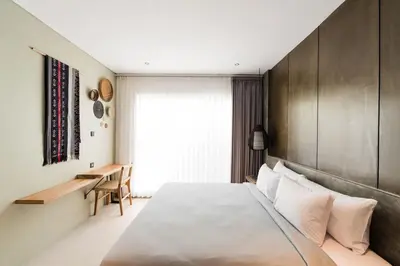 a bedroom with a large bed and a desk at 2 Bedroom Seminyak Apartment -1 in Seminyak