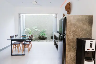 a dining room with a table and a refrigerator at 2 Bedroom Seminyak Apartment -1 in Seminyak