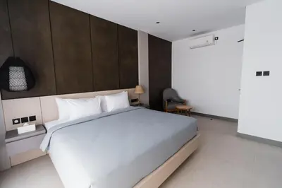a bedroom with a large white bed in a room at 3 Bedroom Seminyak Apartment -3 in Seminyak