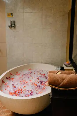 a bath tub covered in confetti in a bathroom at Bali Orchid Spa in Kuta