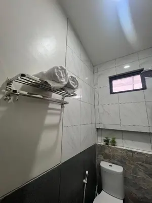a small bathroom with a toilet and a window at Batara Room in Nusa Dua