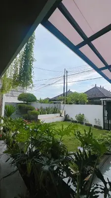 a view of a garden from a patio with plants at Batara Room in Nusa Dua