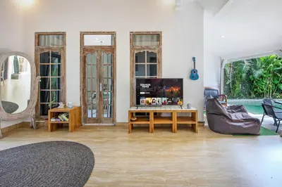 a living room with a couch and a table at Legian Beach Villa - 3-room open villa, private pool, near the beach, Netflix in Legian