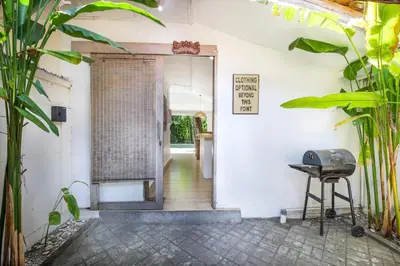 an open door to a room with a table and a grill at Legian Beach Villa - 3-room open villa, private pool, near the beach, Netflix in Legian