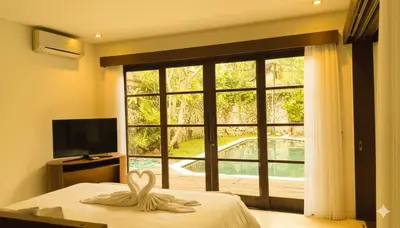 a bedroom with a bed and a large window at Calladi Villa in Seminyak