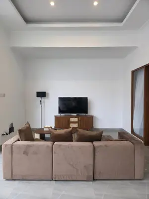 a living room with a couch and a flat screen tv at Le Calme Villa Brand New 2 BR Private Villa near Seminyak in Kerobokan