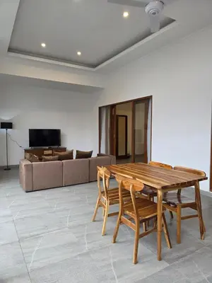 a living room with a wooden table and a couch at Le Calme Villa Brand New 2 BR Private Villa near Seminyak in Kerobokan