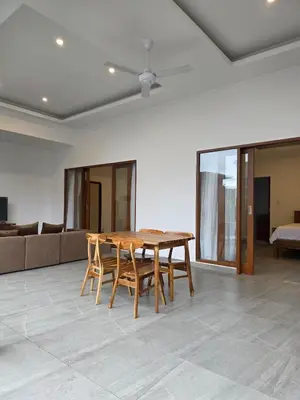 a wooden table and chairs in a living room at Le Calme Villa Brand New 2 BR Private Villa near Seminyak in Kerobokan