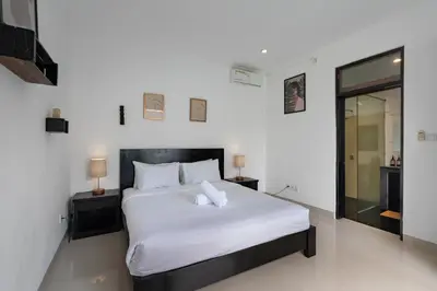 a bedroom with a large white bed with two lamps at Homy 3 Bedrooms Villas in Canggu Umalas in Kerobokan