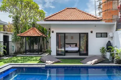 a villa with a swimming pool and a bedroom at Homy 3 Bedrooms Villas in Canggu Umalas in Kerobokan