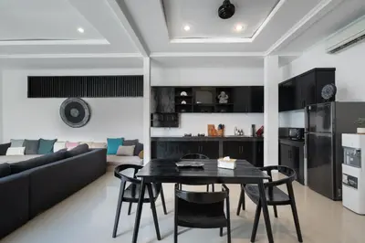 a kitchen and living room with a black table and chairs at Homy 3 Bedrooms Villas in Canggu Umalas in Kerobokan
