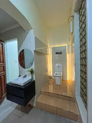 a bathroom with a sink and a toilet and a mirror at Dbelid Royal House - Private 5BR Villa in Jimbaran in Jimbaran