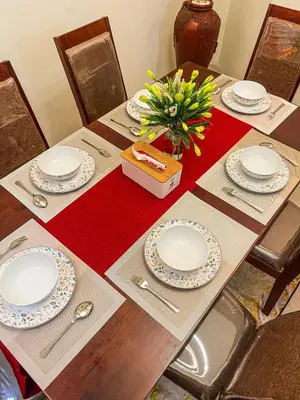 a table with plates and a vase of flowers on it at Dbelid Royal House - Private 5BR Villa in Jimbaran in Jimbaran