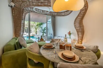 a dining room with a table and a green couch at Magic Day 2BR Private Sauna, Jacuzzi, Projector in Seminyak