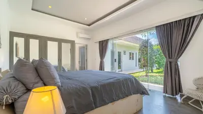 a bedroom with a large bed and a large window at Villa Alana, 3 BR Villa in Kerobokan in Mantaak