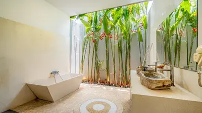 a bathroom with a tub and a large window with plants at Villa Alana, 3 BR Villa in Kerobokan in Mantaak