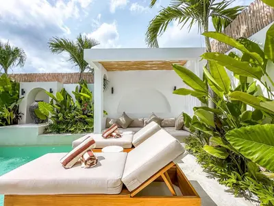 an outdoor living room with a pool and a villa at Villa Nabu - Serene Tropical Escape in Heart of Seminyak in Seminyak