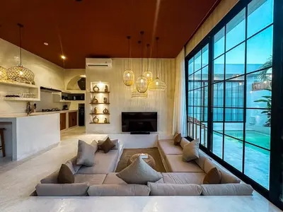 a living room with a large couch and a large window at Villa Nabu - Serene Tropical Escape in Heart of Seminyak in Seminyak