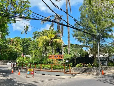 a street with trees and a sign on a road at Private Room, 2 Minutes walk to KuDeTa Beach Seminyak in Seminyak