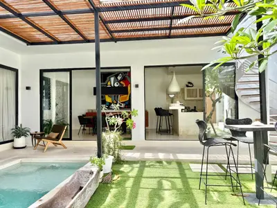 a house with a swimming pool and a dining area at Casa Bali in Kerobokan