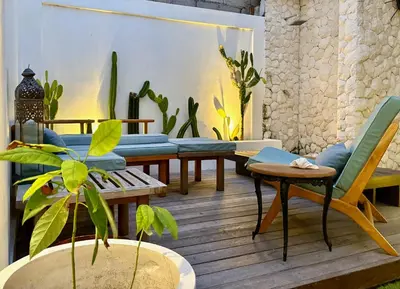 a living room with couches and chairs and plants at Casa Bali in Kerobokan
