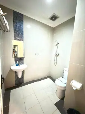 a bathroom with a toilet and a sink at Famora Stay Kuta Bali in Ngurah Rai International Airport