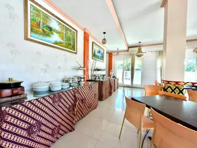a kitchen with a counter and a table and chairs at Famora Stay Kuta Bali in Ngurah Rai International Airport