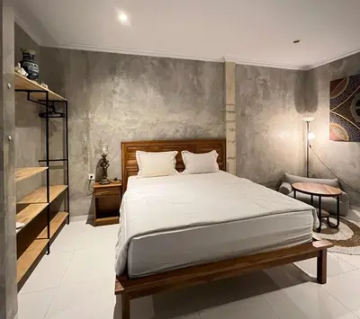 a bedroom with a large bed and a desk at ET Living Cozy Studio Room in Kerobokan