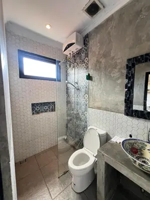 a bathroom with a toilet and a shower and a sink at ET Living Cozy Studio Room in Kerobokan