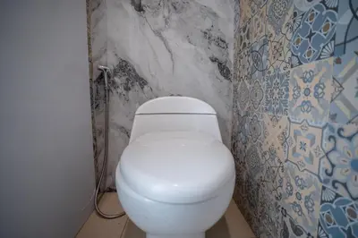 a bathroom with a white toilet in a room at Lumbung Sari Studio in Ngurah Rai International Airport